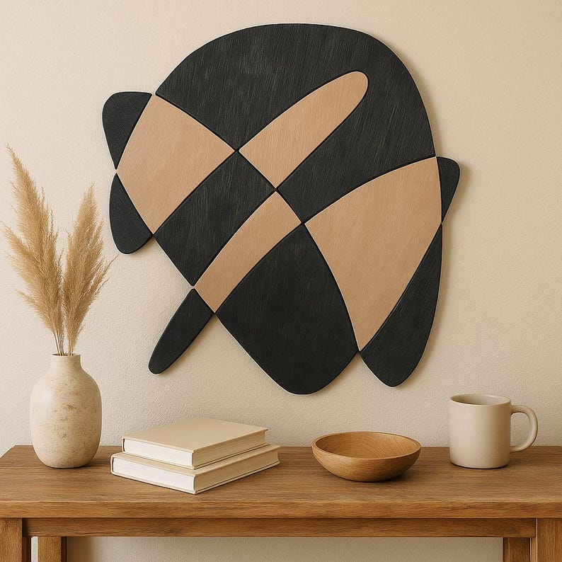 Abstract wall piece of interlocking curved wooden shapes in black and natural wood, hung above a console table